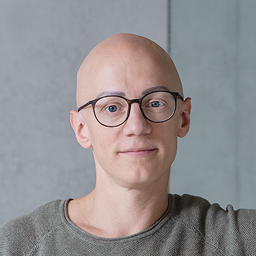 Dennis Kurpierz, Mitgründer und COO von caralegal, Portrait im Büro, an einer Wand lehnend.