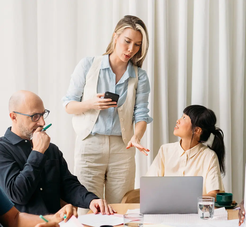 Person im beruflichen Umfeld präsentiert Lösungen für Datenschutz-Management mithilfe von Privacy-Flow am Tisch.