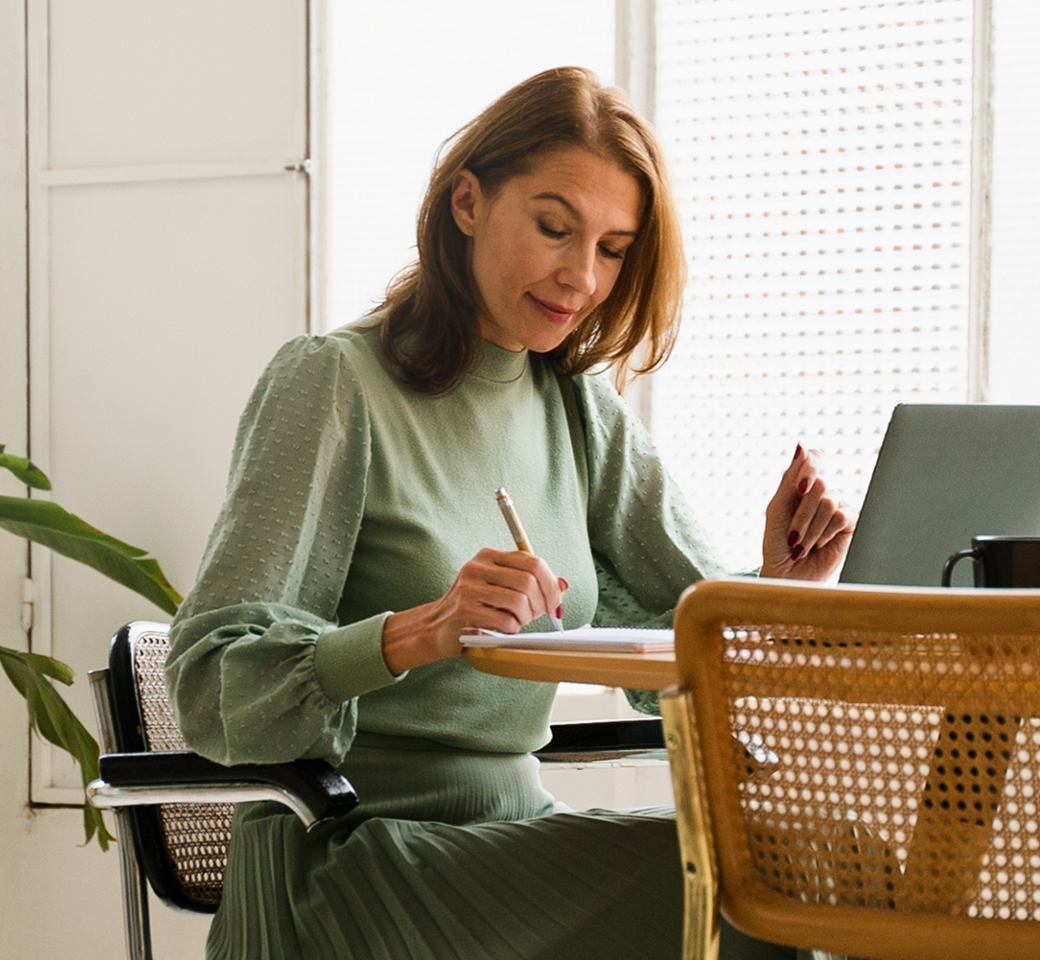 Person arbeitet am Laptop und notiert Gedanken zu Risikoflow in einem modernen Arbeitsumfeld.